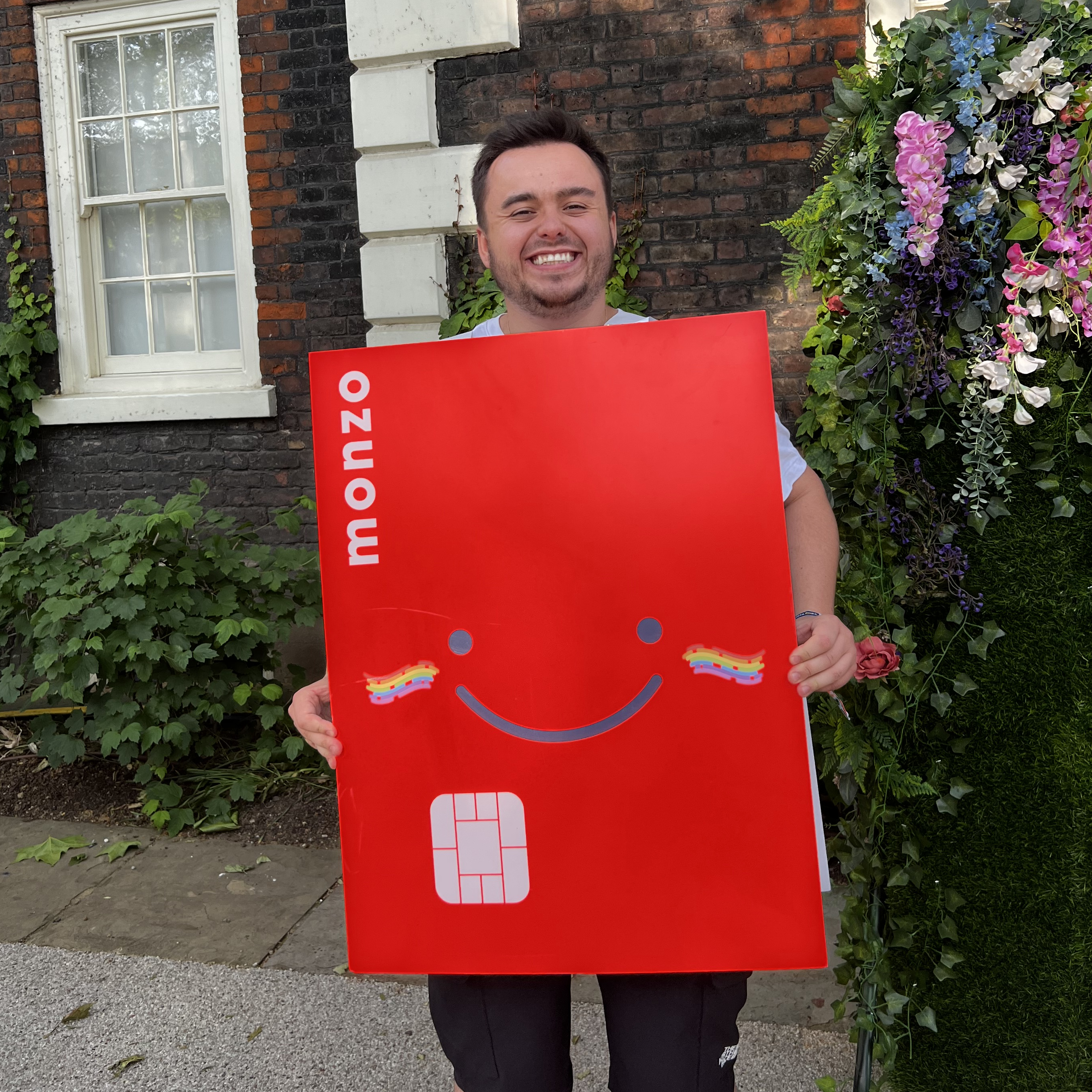 Me on my last day at Monzo, holding an oversized Monzo card
